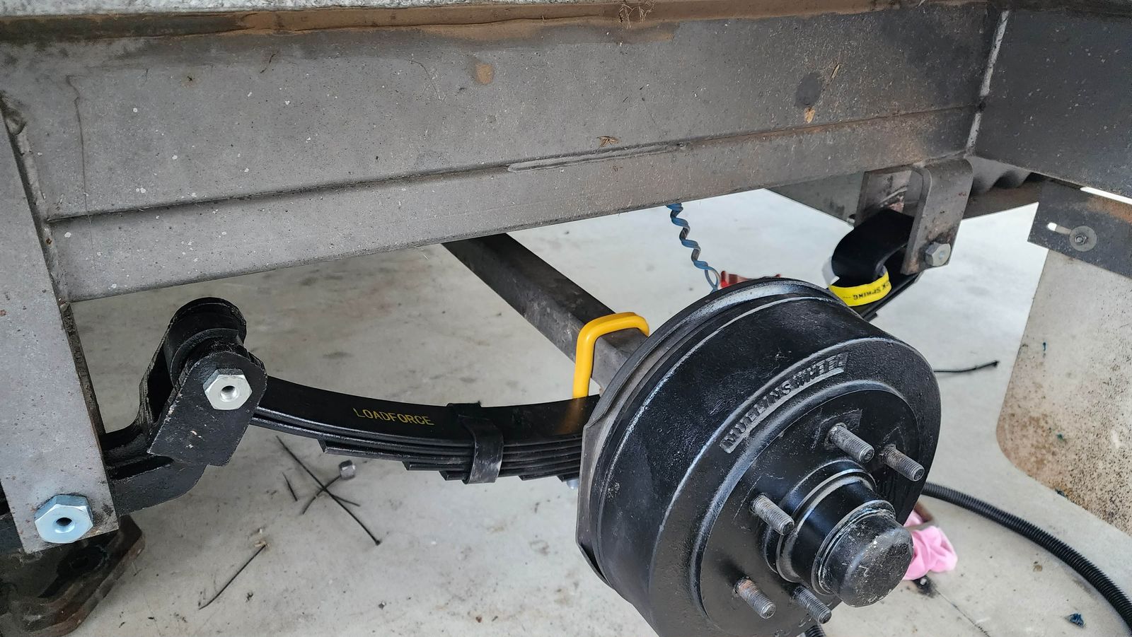 Rocker-roller suspension parts fitted to a caravan โ the rocker arm, bushes and pin mounted on the chassis